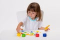 Close-up portrait of a cute cheerful happy smiling little girl draws her own hands with gouache or finger paints isolated on white Royalty Free Stock Photo