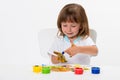 Close-up portrait of a cute cheerful happy smiling little girl draws her own hands with gouache or finger paints isolated on white Royalty Free Stock Photo