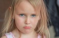 Close-up portrait of cute five year old blonde who looks resentful