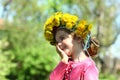Close up portrait of a cute laughing two years old girl wearing a dandelion wreath Royalty Free Stock Photo