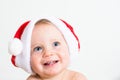 Close up portrait of a cute little baby with red Santa Claus hat isolated on white background. Small smiling kid face with blue Royalty Free Stock Photo