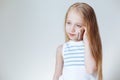 Close up portrait of Cute little blonde European girl in casual clothes talking on the mobile phone and smiling.White Royalty Free Stock Photo