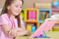 Close up portrait of cute little girl reading book