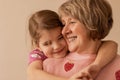 Close up portrait of cute little granddaughter hugging her beautiful grandmother, enjoying leisure time together Royalty Free Stock Photo