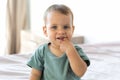 close-up portrait of a cute 10 month old baby with his finger in his mouth, drooling, new teeth growing Royalty Free Stock Photo