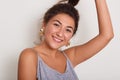 Close up portrait of cute and smiling lady with dark wavy hair, young girl with pony tail looking directly at camera, adorable