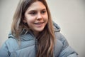 Close-up portrait of cute smiling teenage girl with braces wearing in warm coat looking away against blurred background Royalty Free Stock Photo