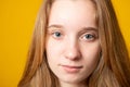 Close-up portrait of a cute young girl. Studio portrait of a smiling teenage girl on a yellow background Royalty Free Stock Photo