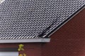 A close up portrait of a damaged black tile roof of a house. The building got destroyed by a big storm with high wind speeds on Royalty Free Stock Photo