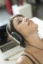 Close-up portrait of daydreaming beautiful smiling girl, woman in headphones and ponytail, using trendy clothes