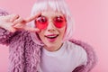 Close-up portrait of debonair girl in trendy peruke. Indoor shot of laughing young woman in sunglas