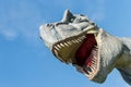 Close-up portrait of dinosaur tyrannosaurus against blue sky