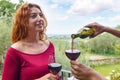 Close up portrait of a diverse couple outdoor celebrating happy hour in the nature. focus on the glass and hands pouring wine. Royalty Free Stock Photo