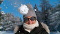 CLOSE UP: Fluffy snowball flies towards an unsuspecting smiling Caucasian woman. Royalty Free Stock Photo