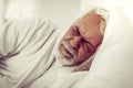 Close-up portrait of an elderly bearded wrinkled man experiencing pain