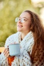 Close up portrait of enjoying and inspired young beautiful girl covered with blanket and drinking warm hot cup of coffee Royalty Free Stock Photo