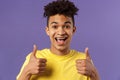 Close-up portrait of enthusiastic, lively hipster guy with afro haircut agree with something, show thumbs-up smiling