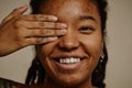 Close up ethnic young woman smiling candidly with one eye closed