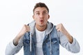 Close-up portrait of excited and amused blond young man watching sport game on tv screen, anticipating important moment