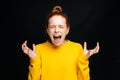 Close-up of excited angry young woman screaming with closed eyes on isolated black background.