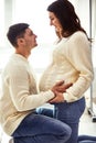 Close up portrait of expecting teenage couple laughing happily, embracing baby in belly together. Couple dressed in blue Royalty Free Stock Photo