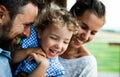 Close-up portrait of family with small daughter by wooden cabin, holiday in nature concept. Royalty Free Stock Photo