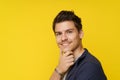 Close-up portrait features a smiling, handsome young man with his hand near his chin, exuding confidence, charm, and Royalty Free Stock Photo