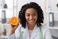 Close up portrait of female doctor holding orange half Royalty Free Stock Photo