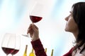 Female sommelier evaluating red wine against clear background