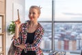 Close-up portrait of a female painter holding paintbrush, watching at camera, smiling. Creative artist finished new Royalty Free Stock Photo