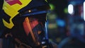 Close up, portrait of firefighter wearing gas mask in front of the burning house