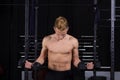 Close Up portrait of a fit young man lifting weights in gym on dark background. Royalty Free Stock Photo