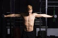 Close Up portrait of a fit young man lifting weights in gym on dark background. Royalty Free Stock Photo