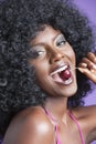 Close-up portrait of a flirtatious young woman with fizzy hair eating cherry