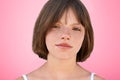 Close up portrait of freckled stylish small kid looks with narrow dark eyes directly into camera, has serious expression, isolated