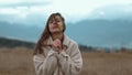 close up portrait of freezing ukrainian woman stands outdoors at cold cloudy autumn day. girl tryes to warm her frozen