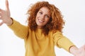 Close-up portrait, friendly and lovely, smiling happy curly redhead woman in yellow sweater, tilt head silly grinning Royalty Free Stock Photo