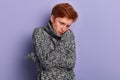 Close up portrait of a frozen unhappy sad young man hugging himself