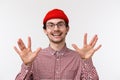 Close-up portrait funny hipster guy in red beanie and glasses make spok gesture showing fingers and smiling, discuss