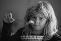 Close up portrait of funny kid eating. Sad boy eating healthy chicken noodle soup for lunch. Unhappy baby child taking Royalty Free Stock Photo