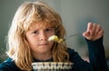 Close up portrait of funny kid eating. Sad boy eating healthy chicken noodle soup for lunch. Unhappy baby child taking Royalty Free Stock Photo