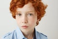 Close up portrait of funny little kid with orange hair and freckles. Boy looking in camera with relaxed and calm face Royalty Free Stock Photo