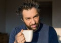 Close up portrait of a funny man after awakening with a big cup. Royalty Free Stock Photo