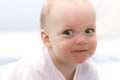 Close-up portrait of funny smiling baby boy and looking at camera. Smirking big-eyed infant kid. Royalty Free Stock Photo