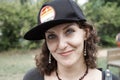 Close up portrait of the funny smiling woman with curly hair wearing the baseball cap