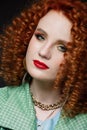 Close-up portrait of  girl, curly red hair, red lipstick, calm look, white skin, puffy hairstyle, evening make-up Royalty Free Stock Photo