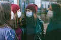 Close-up portrait of girls with medical masks. Against the background of a glass building with reflections. Concept on the topic
