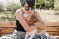 Close-up portrait of glad brunette lady embracing her beagle dog with gently smile. Outdoor photo of happy girl in