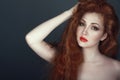 Gorgeous red headed woman with beautiful make up holding her hand in her hair Royalty Free Stock Photo