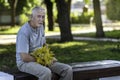 Close-up portrait of a grandfather with gray hair and mustache, sitting on a bench in a city Park on a date Royalty Free Stock Photo